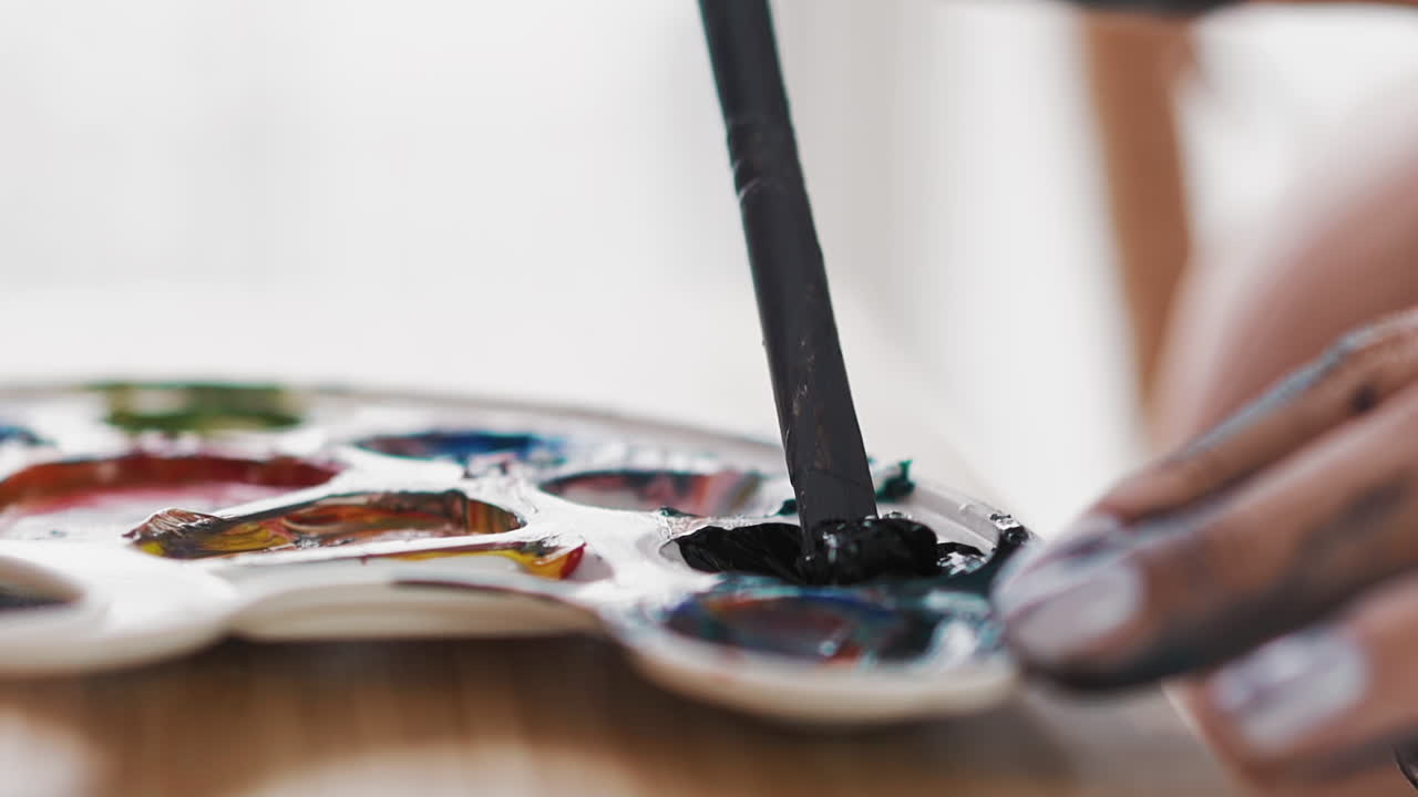 el artista mezcla pintura azul en una taza de paleta blanca en el caballete
