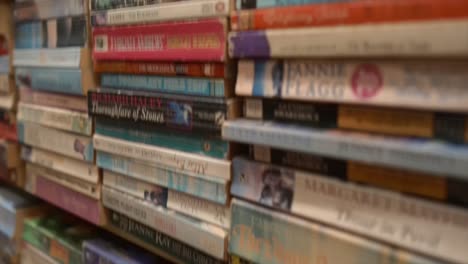 toma de seguimiento de estanterías con diferentes pilas de libros juntos, primer plano