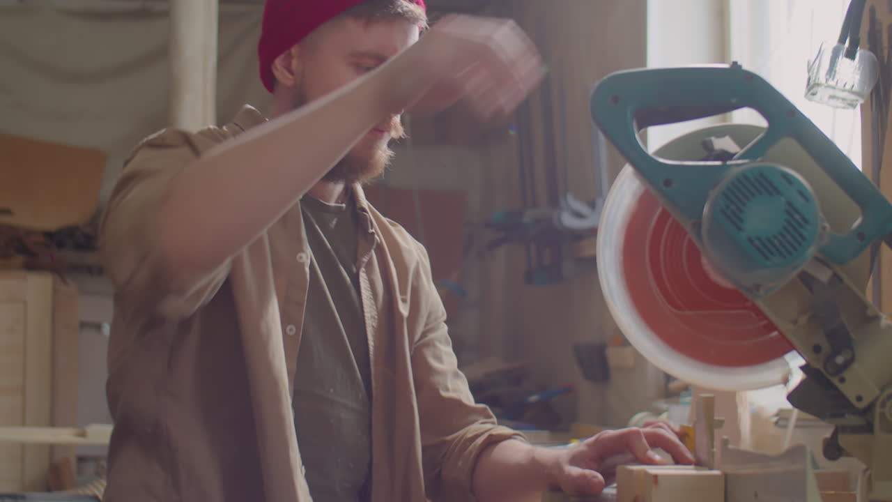 плотник режущая доска с митерной пилой в деревообрабатывающей мастерской