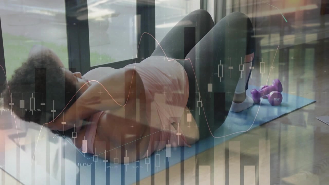 Kvinde ligger på blå måtte nær vinduer, kigger på bærbar computer og laver mavebøjninger for fitnessvejledning.