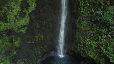 high angle view of a waterfall cascading down mossy rocks in a lush forest