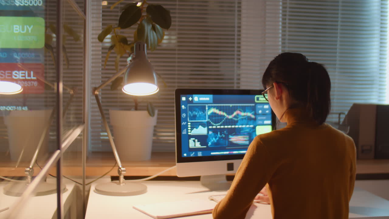 사업가 여성이 밤에 사무실에서 주식 시장 분석을 하고 있습니다.