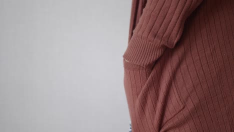 close up of a brown ribbed sweater with a pocket