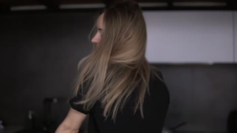 una chica delgada baila sensualmente en la cocina con un moderno interior de loft