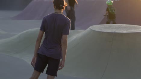 slow motion shot of boy on skateboard riding at park during sunset