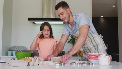 Happy-caucasian-father-and-daughter-baking-together-in-kitchen