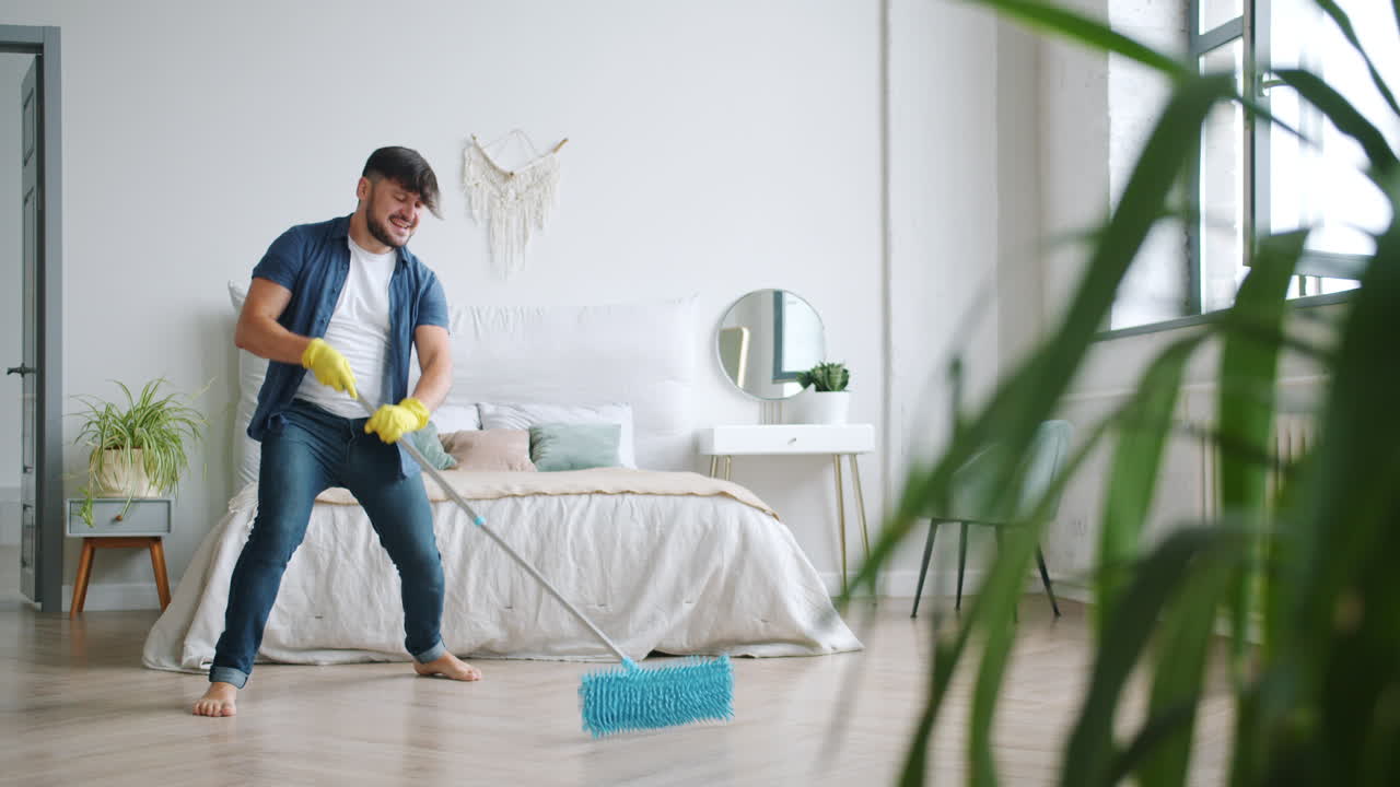 Man Cleaning and Dancing in Bedroom