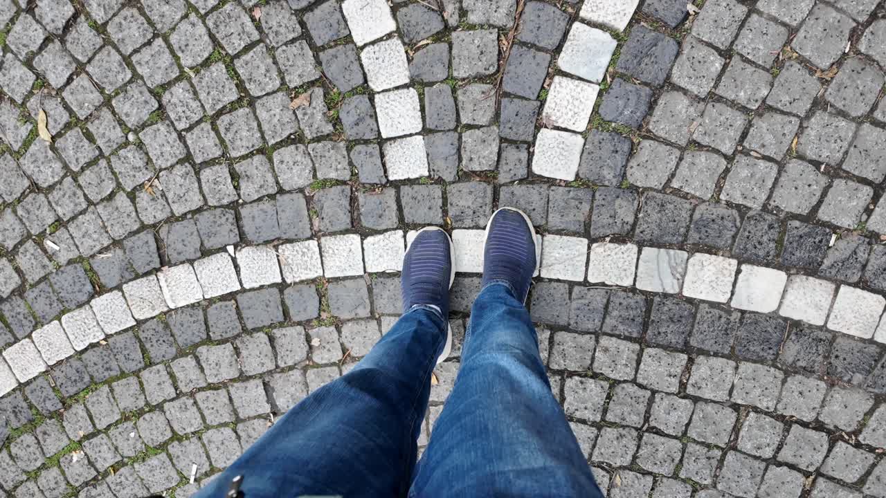 A person standing on a cobblestone street
