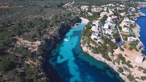 4k aerial footage of a tropical bay on a sunny day with crystal clear water in mallorca, spain