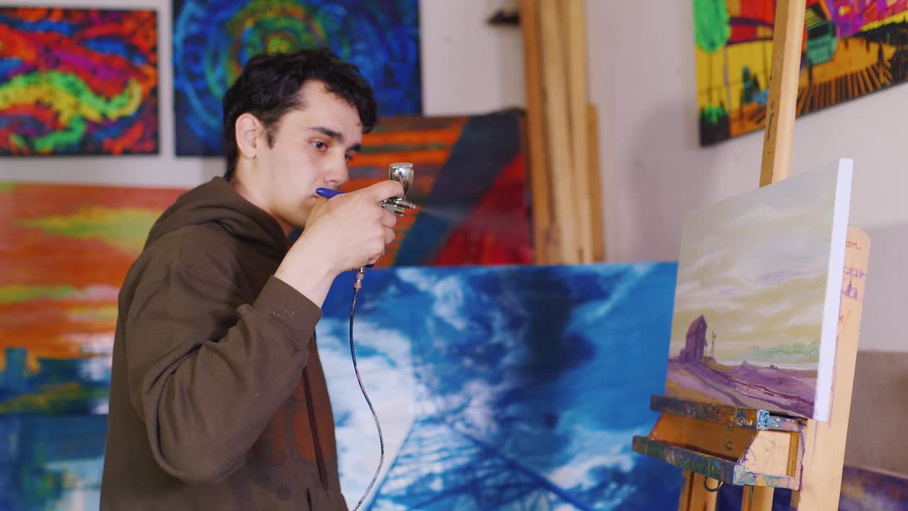 작가는 에어 브러시 페인팅을 처리합니다.