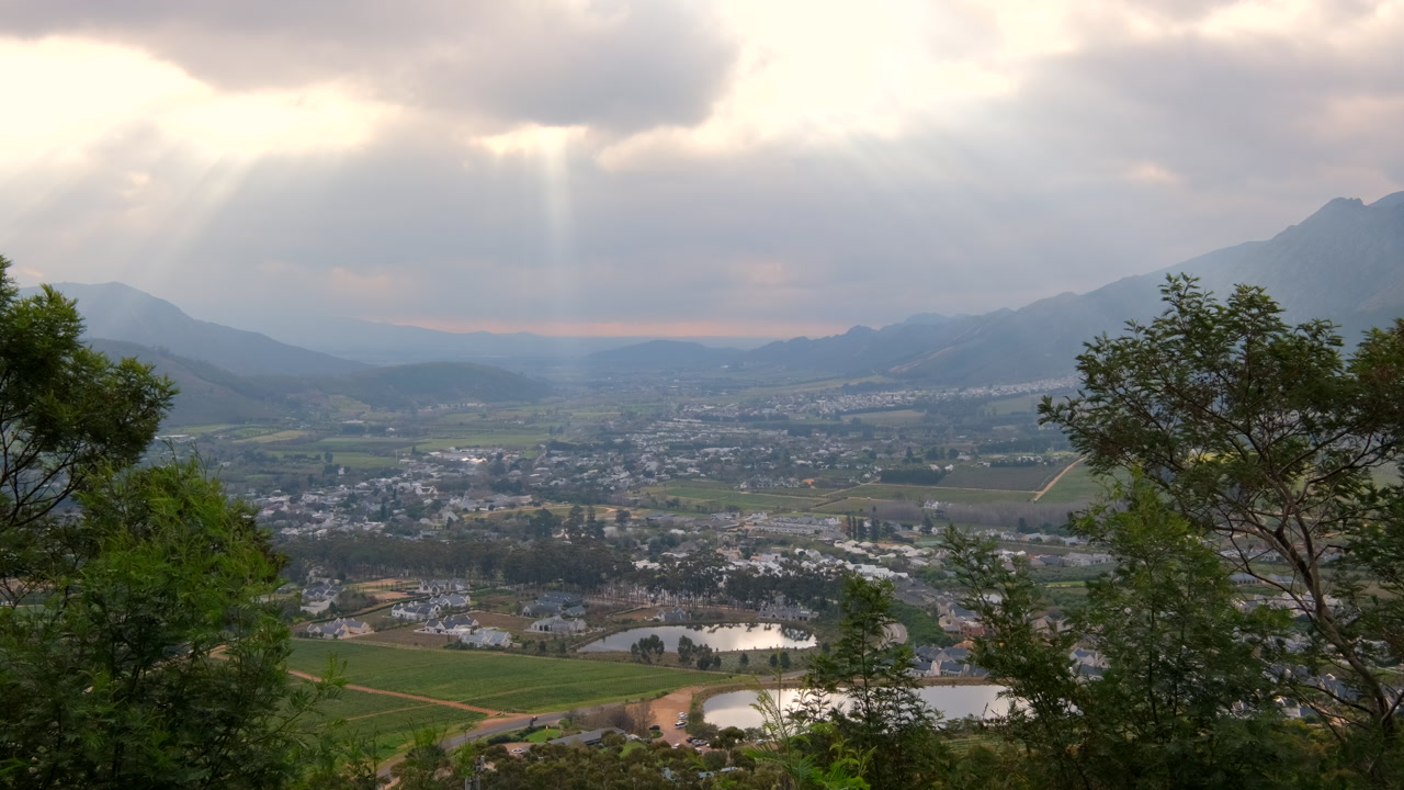 Crepuscular rays illuminate tourist destination of Franschhoek, lookout point