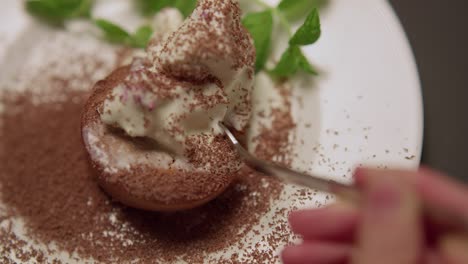 A-person-using-a-fork-to-eat-pastries-from-a-plate