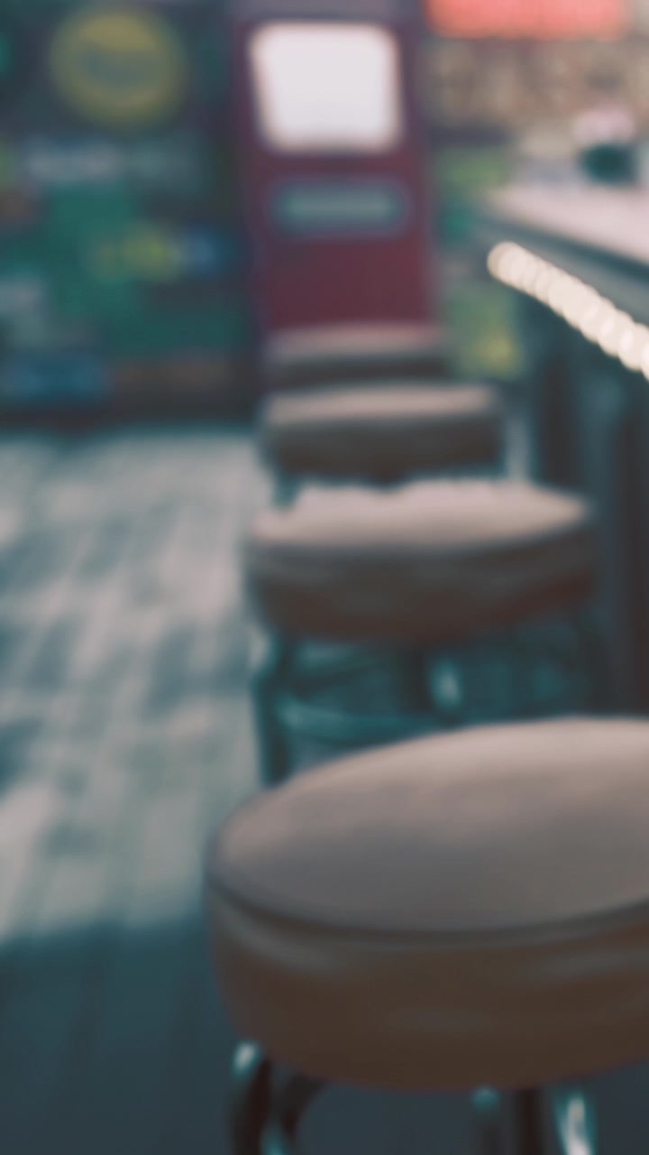 Stools at a bar with a bright backdrop on a sunny day