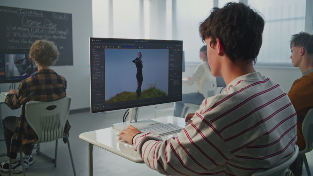 Student in Striped Sweatshirt Creates 3D Animation on Computer in Modern Classroom