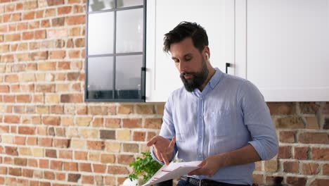 Tracking-video-of-man-with-headphones-refusing-documents-at-home