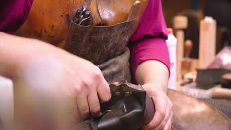 bespoke shoemaker pinning leather together to make shoe