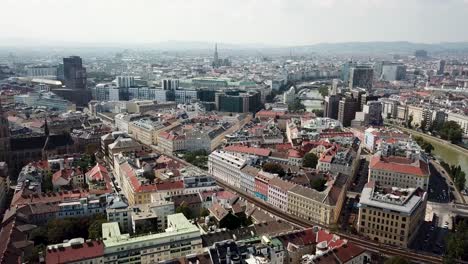 danube river with old town of vienna and modern downtown in background. office buildings in capital of austria. aerial drone wide shot.