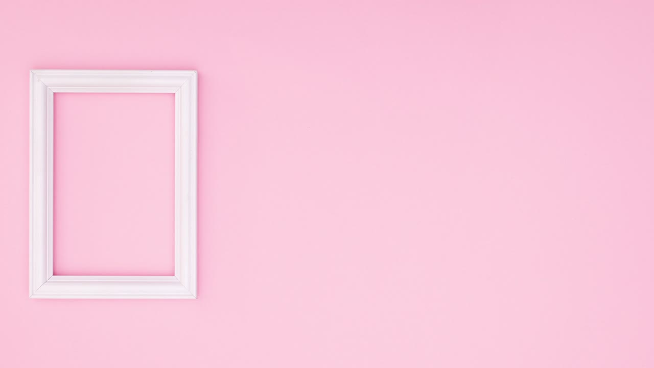 Green leaf falling next to white romantic frame on pink theme. Stop motion
