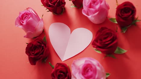 red and pink roses with heart on red background at valentine's day