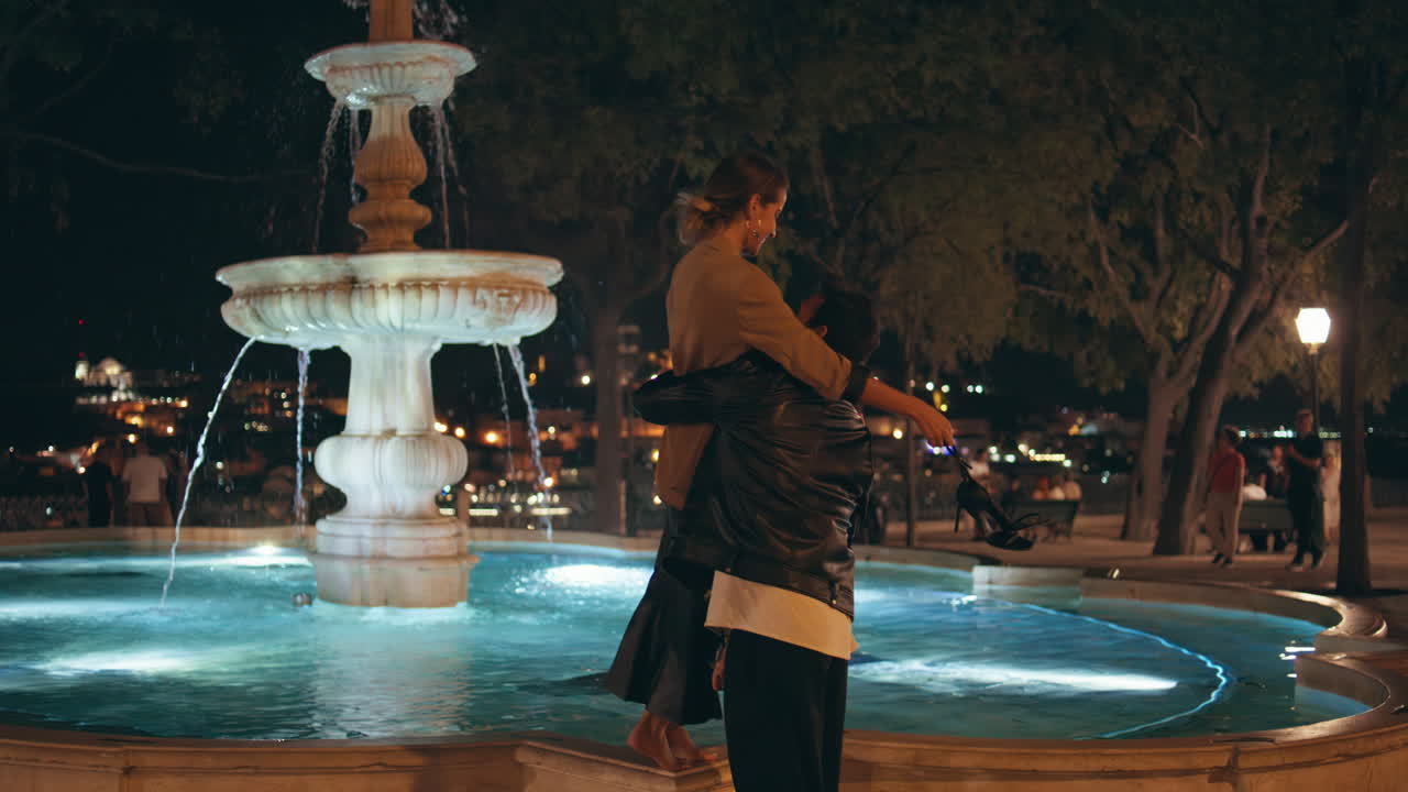 Romantic couple walking date in city night. Happy man holding spinning woman