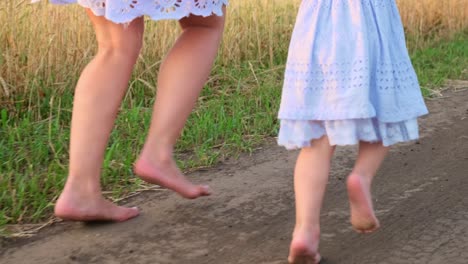 mother and daughter barefoot on a country road