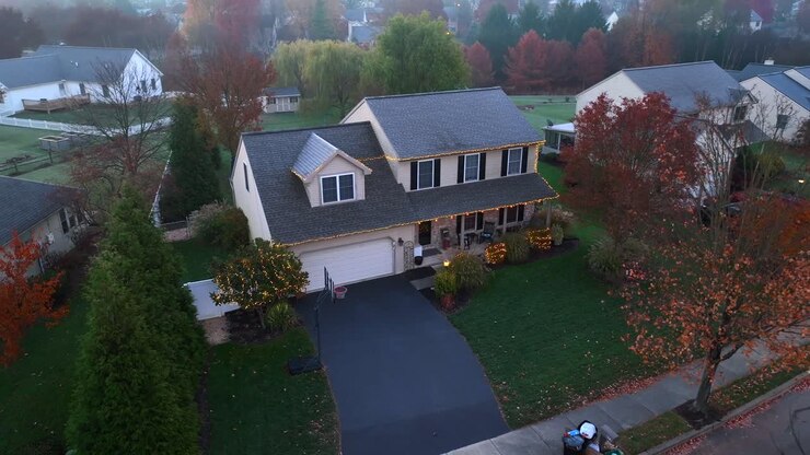 Two story traditional American home decorated with Christmas lights at holidays