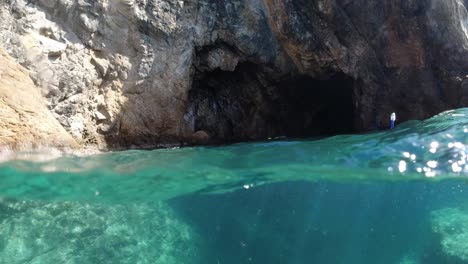 snorkeler swimming toward a sea cave