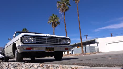 exterior establishing shot of a palm springs california mid century modern home with classic retro car parked in garage