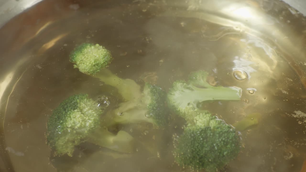 Close Up Of Broccoli Dropped Into The Boiling Soup Pot. Vegetarian Concept. Sukiyaki Or Shabu