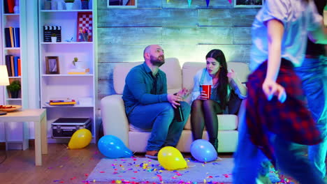 group of people dancing at a party with neon lights in apartment