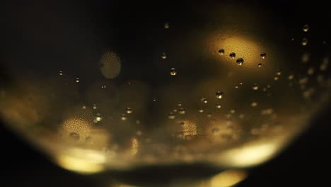 Champagne-sizzling-bubbles-rising-from-the-bottom-of-a-glass---Extreme-close-up-shot