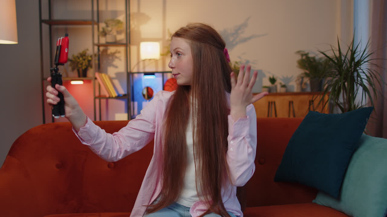 niña blogger tomando selfies en su teléfono inteligente comunicándose por video llamada a casa en línea con suscriptores