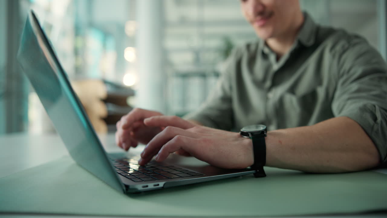 Man Typing on Laptop Keyboard in Modern Office