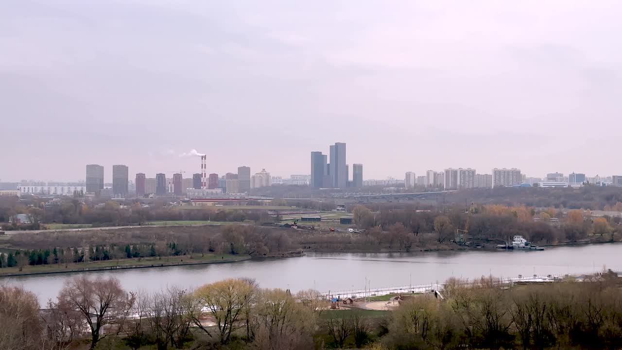 Panorama of the autumn city over the river (4K60)