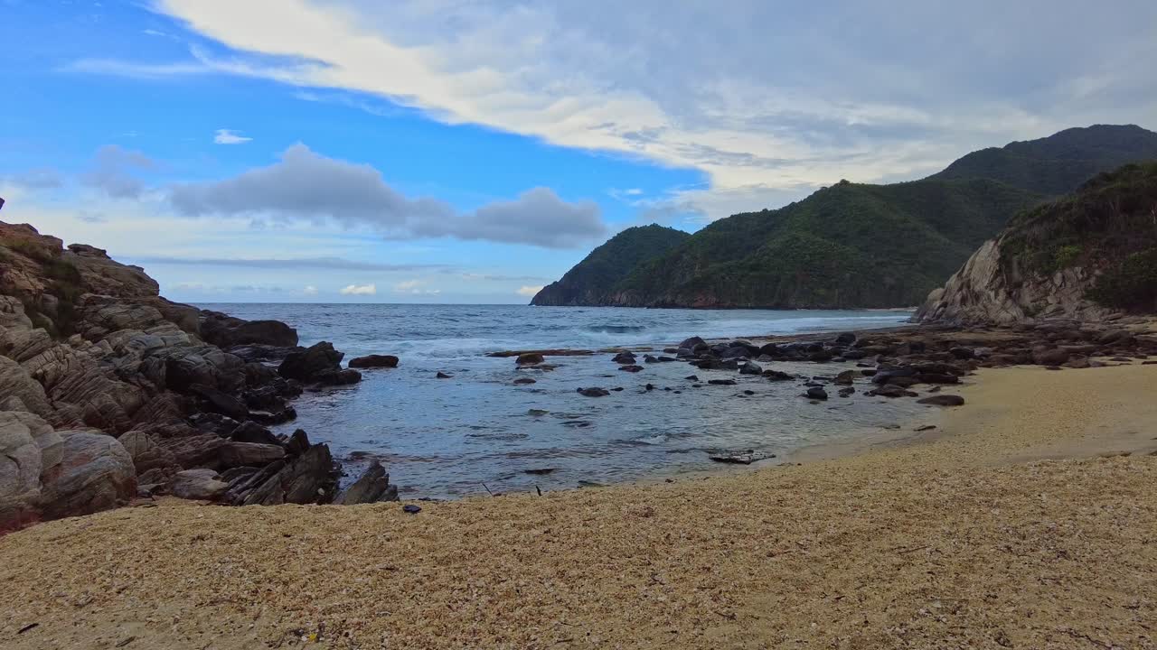 Inquadratura in soggettiva che mostra la spiaggia di Puerto Escondido nella Baia di Cepe, sulla costa venezuelana affacciata sul Mar dei Caraibi, senza persone in vista.