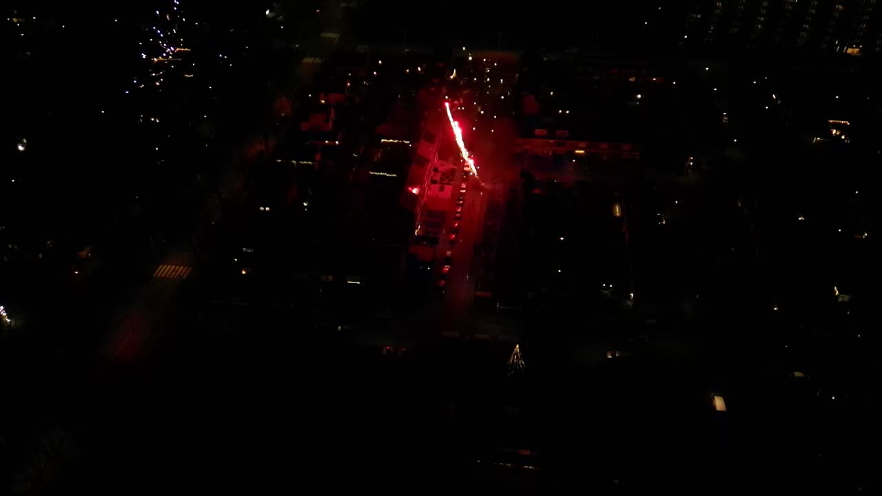 Aerial View Of Fireworks Going Off In Urban Street At Night