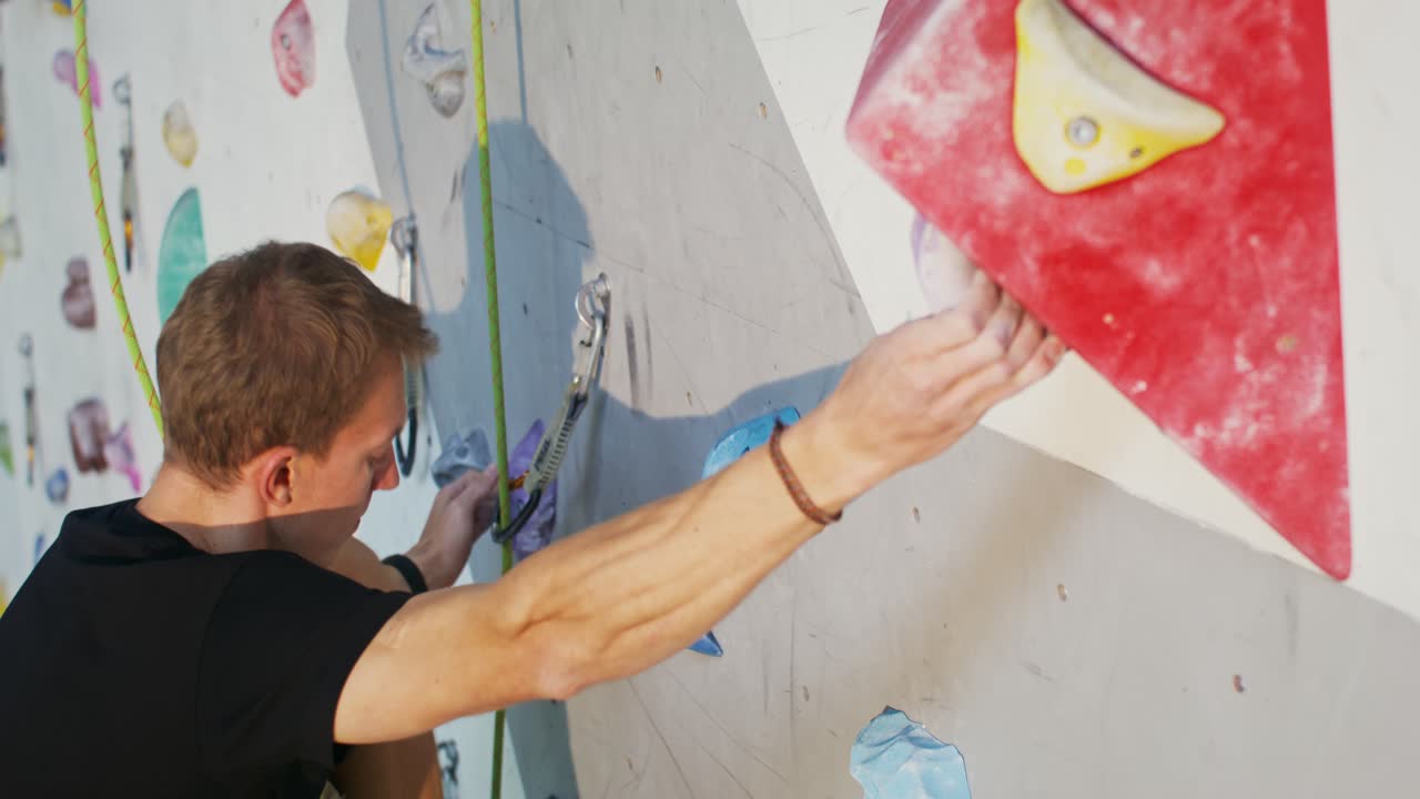 hombre escalando roca en la pared de escalada interior