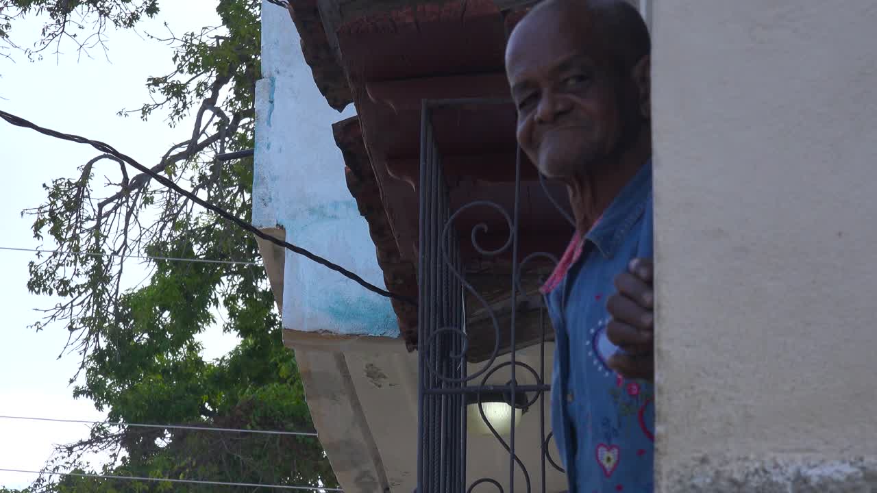 친근한 노인이 쿠바 트리니다드에서 엄지손가락을 치켜세우고 미소 짓는다