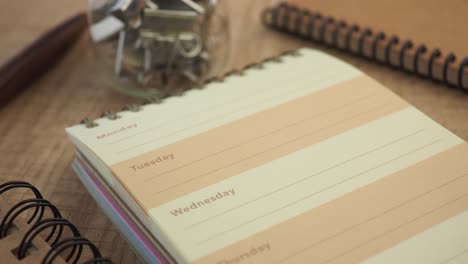 spiral bound notebook and office supplies on a wooden desk