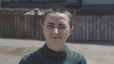 Portrait-Of-A-Young-Lesbian-Standing-And-Frowning-On-A-Hot-Summer-Day