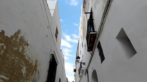 pov mirando hacia arriba mientras camina por las estrechas calles de la ciudad con el cielo azul