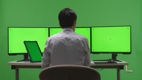 persona de negocios que trabaja en múltiples monitores