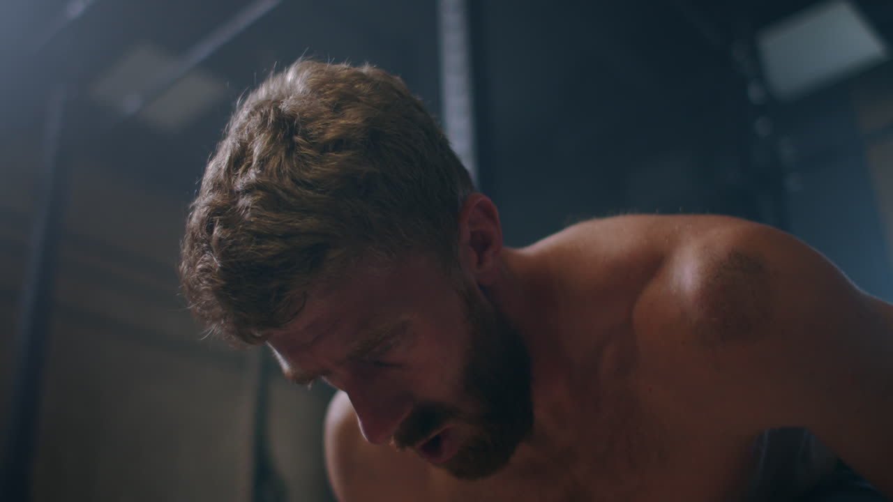 커다란 하드코어 체육관에서 무거운 바벨로 운동하는 젊은 백인 극단적인 웨이트리프팅 운동선수 남자.