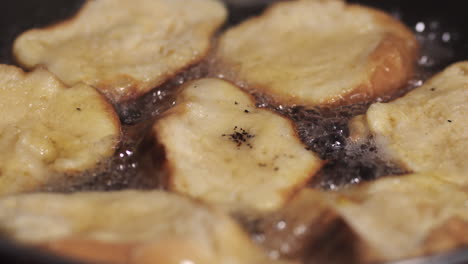 preparing rabanadas , frying the egg soaked bread - extreme close up