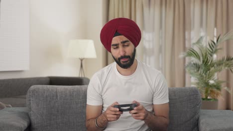 sleepy and tired sikh indian man playing video games