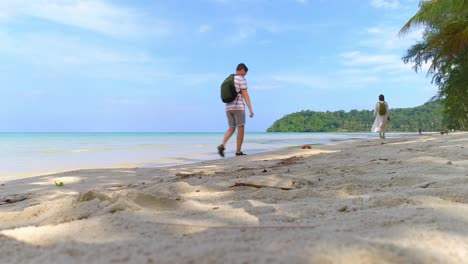 una pareja caminando por una hermosa playa tropical.