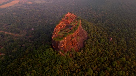 a breathtaking aerial view of sigiriya rock at dawn, with the ancient fortress illuminated by the soft first light of the day.