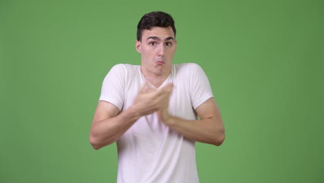 young handsome man shrugging shoulders