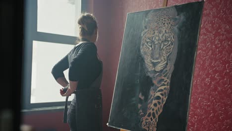 woman artist viewing a leopard painting