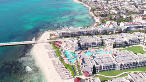 Drohnenaufnahme-Von-Luxuriösen-Gebäuden-Und-Pier-Am-Wasser-In-Playa-Del-Carmen,-Mexiko